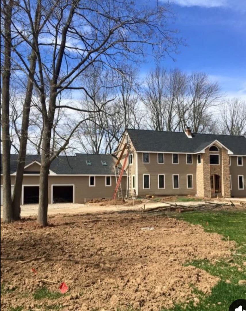 Large house with trees and clear sky.